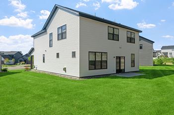 A modern house with a grey exterior and a black roof.